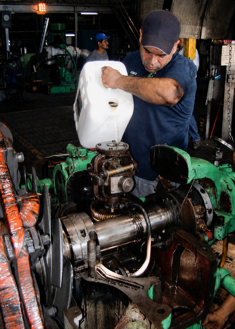 Operario aplicando Muscle MT-10 directamente en maquinaria industrial